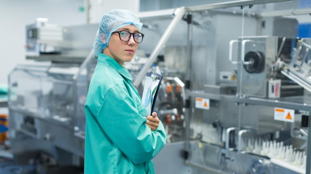 девушка стоит в чистом помещении для производства
